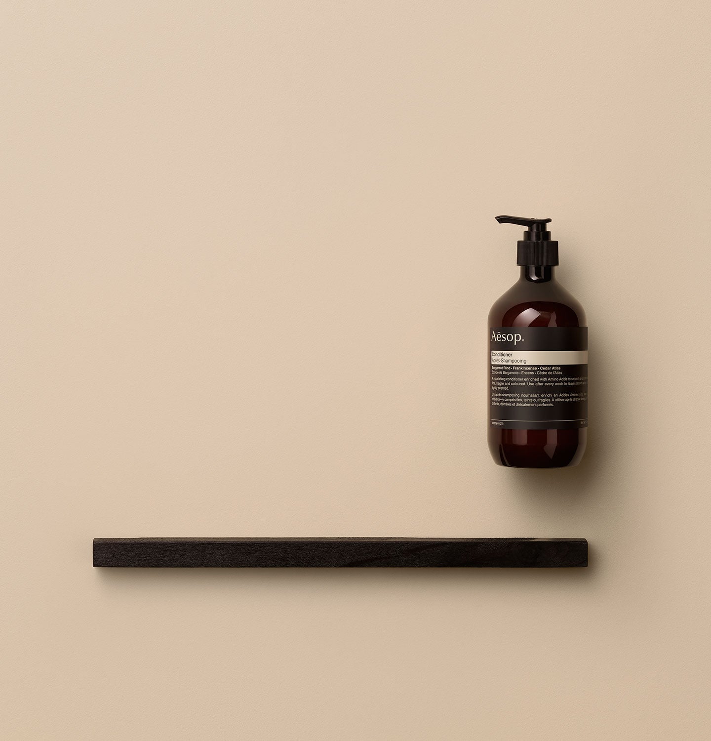 500ml bottle of Aesop Conditioner placed by a wooden plank