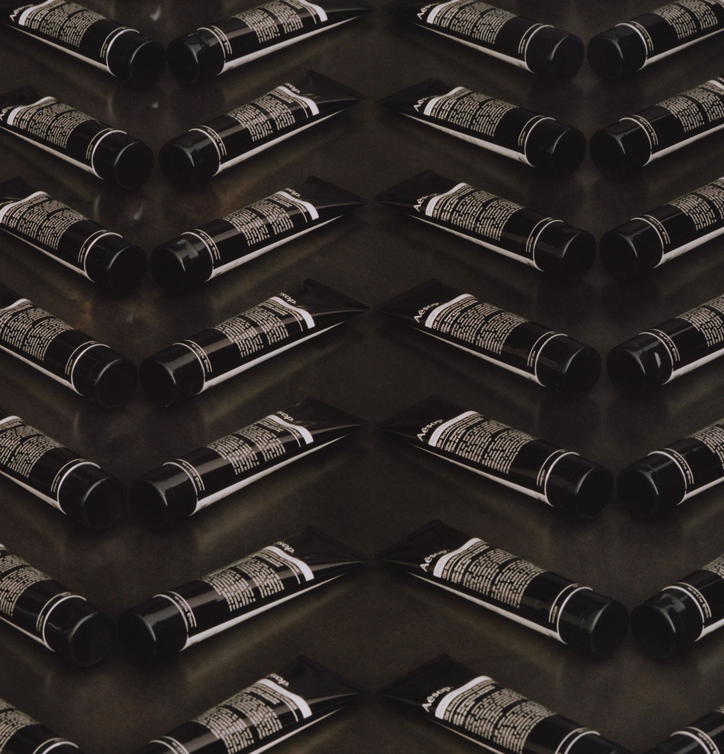 Multiple tubes of Aesop Sculpt Hair Polish stacked in rows