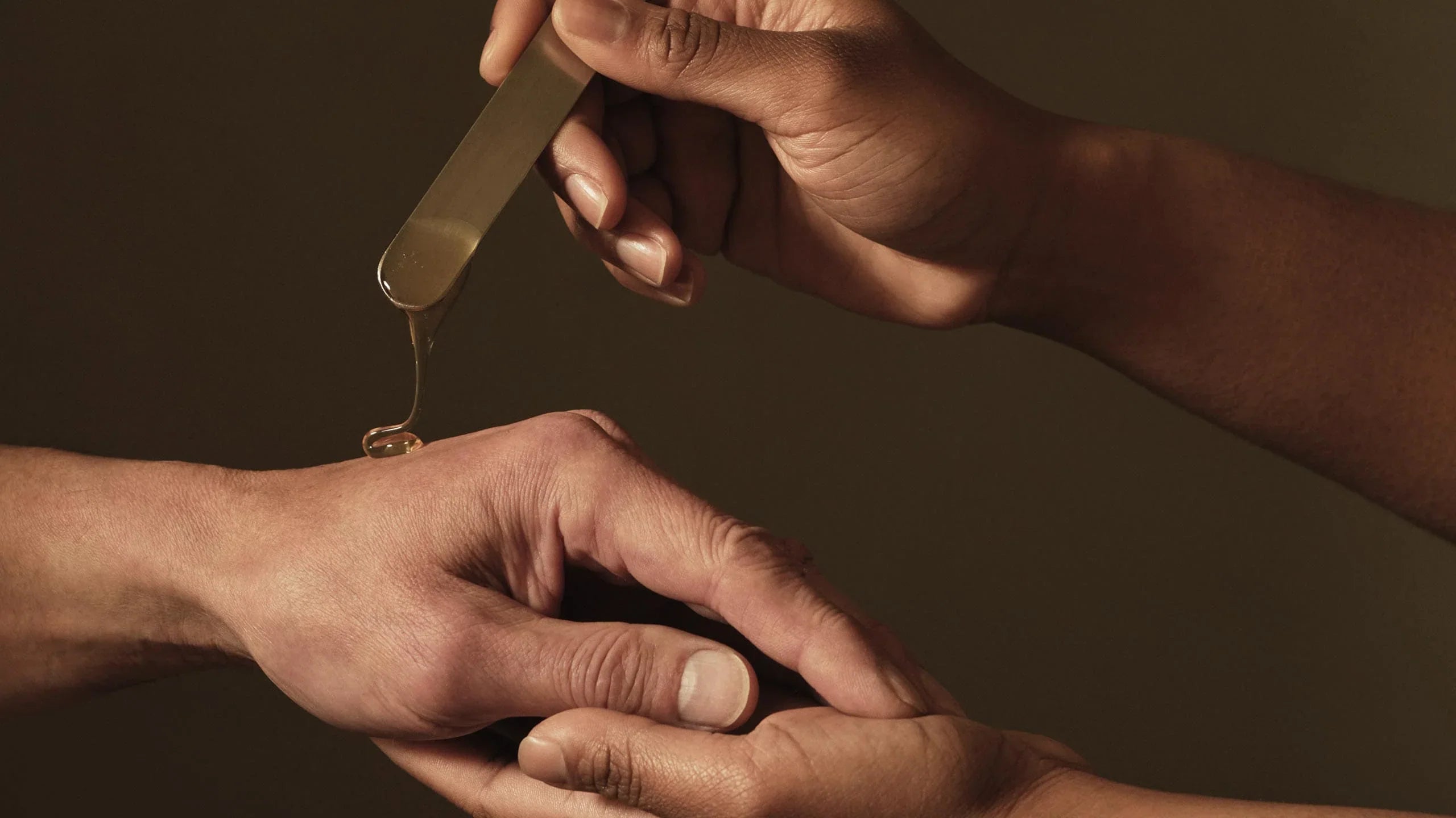 A pair of hands applying Aesop product on another hand