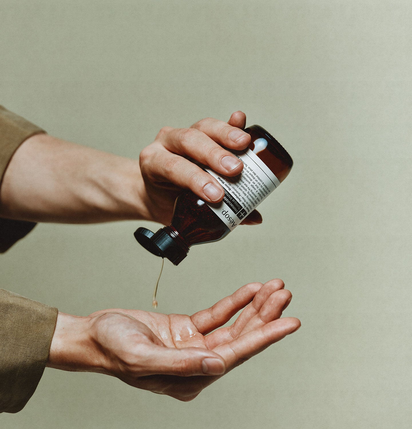 A pair of hands using the Aesop Immaculate facial tonic