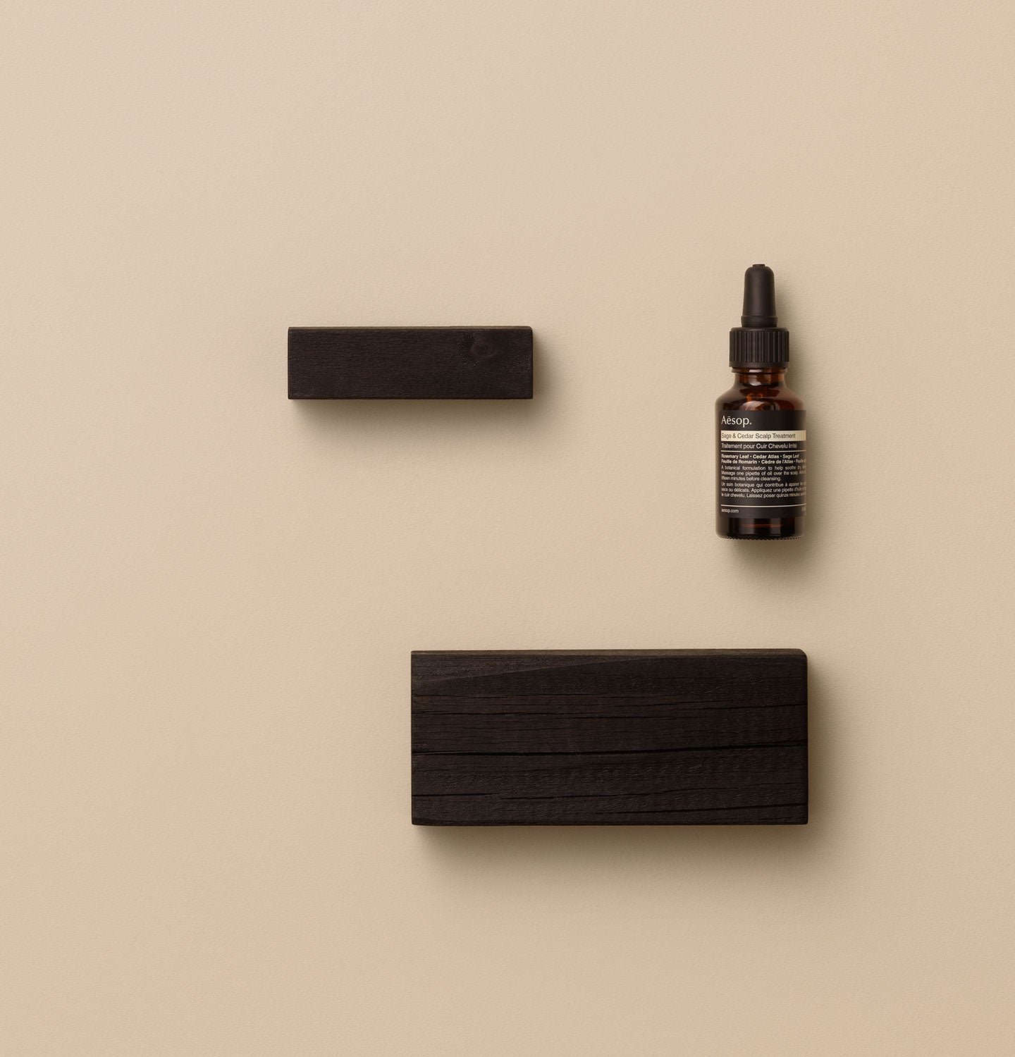 25ml bottle of Aesop Sage & Cedar Scalp Treatment placed by blocks