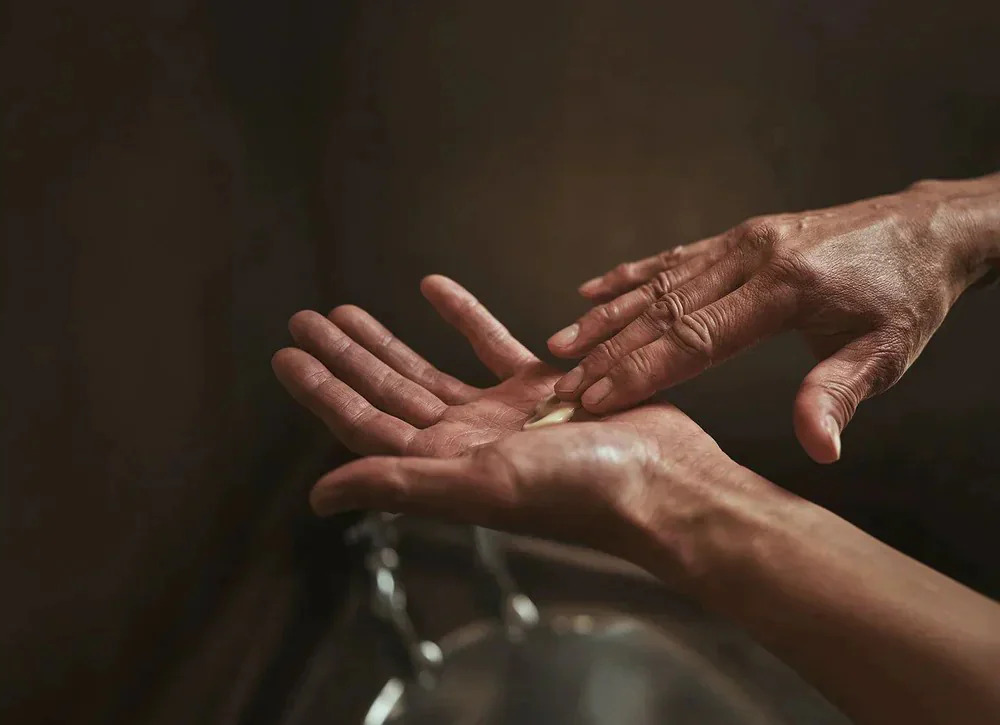 A pair of hands rubbing Aesop product between them