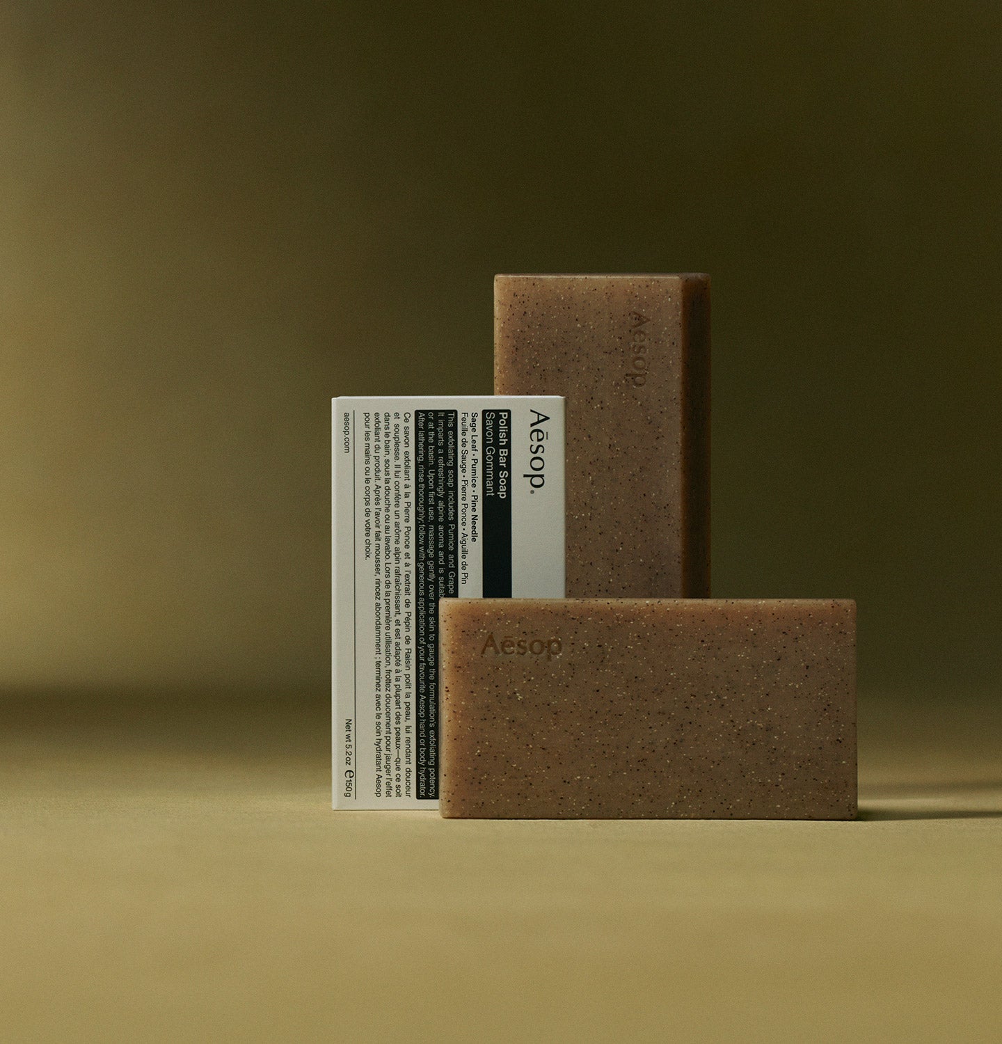 two bars of Aesop Polish Bar Soap and a box of Aesop Polish Bar Soap placed on a surface